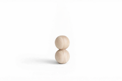 Two stacked wooden spheres on a white background