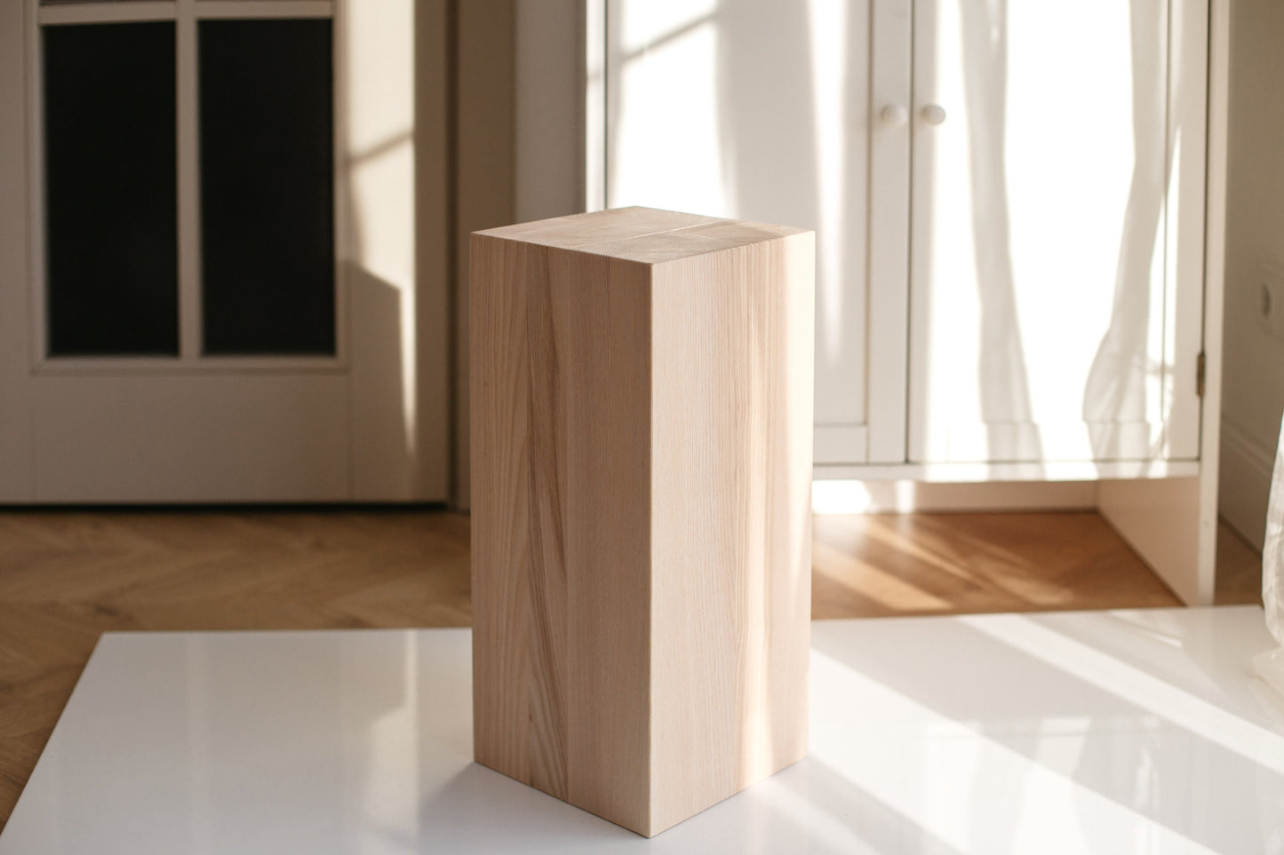 A handmade solid ash wood coffee table with a smooth, polished finish, displayed in a room with natural lighting.