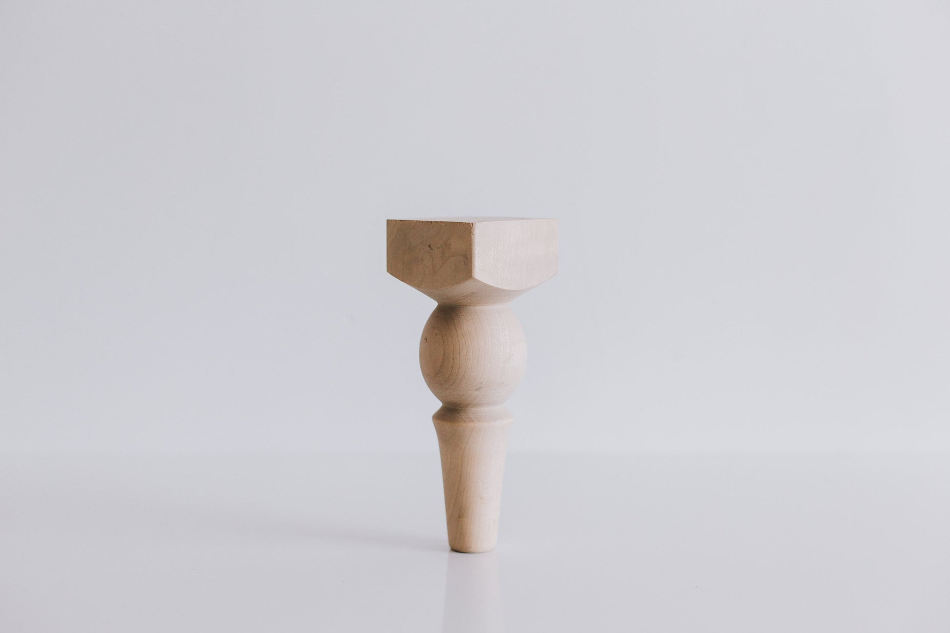 A single wooden furniture leg with a ball design at the top, displayed against a white background.