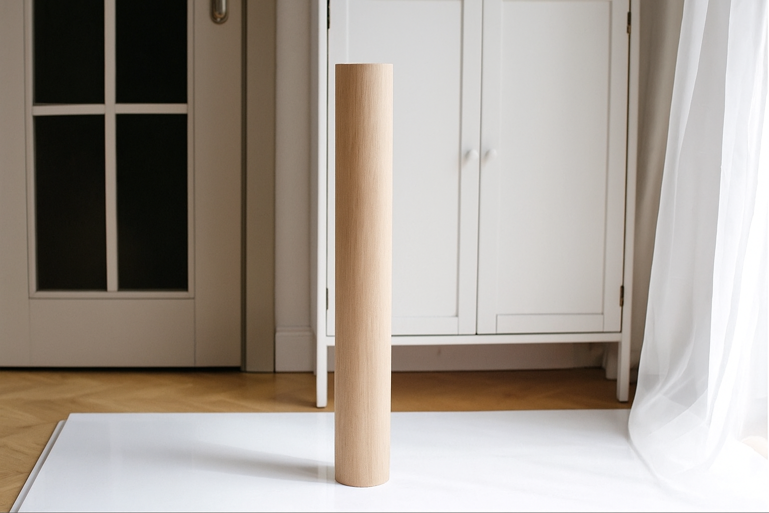 Wooden leg of a piece of furniture on a white rug with a neutral background