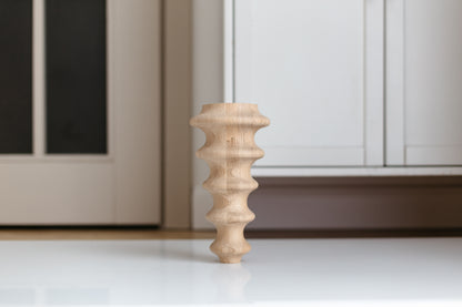 Wooden leg of a piece of furniture against a neutral background