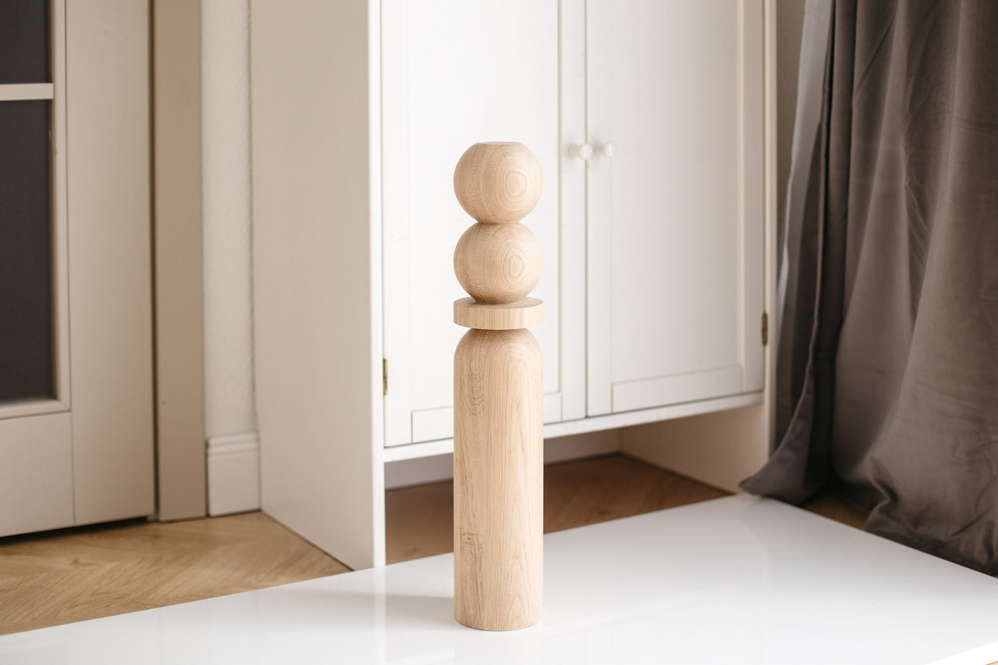 Wooden bed post in a bedroom setting with neutral colors