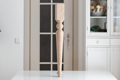 Wooden leg on a white surface with a kitchen background