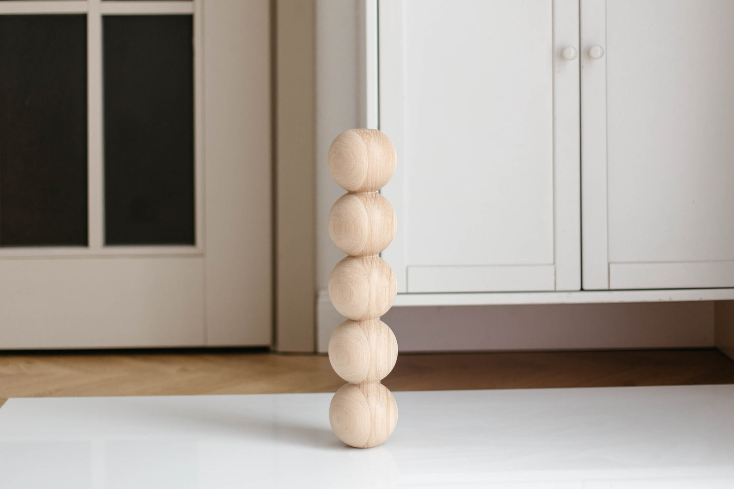 Wooden leg with spherical design on a white surface