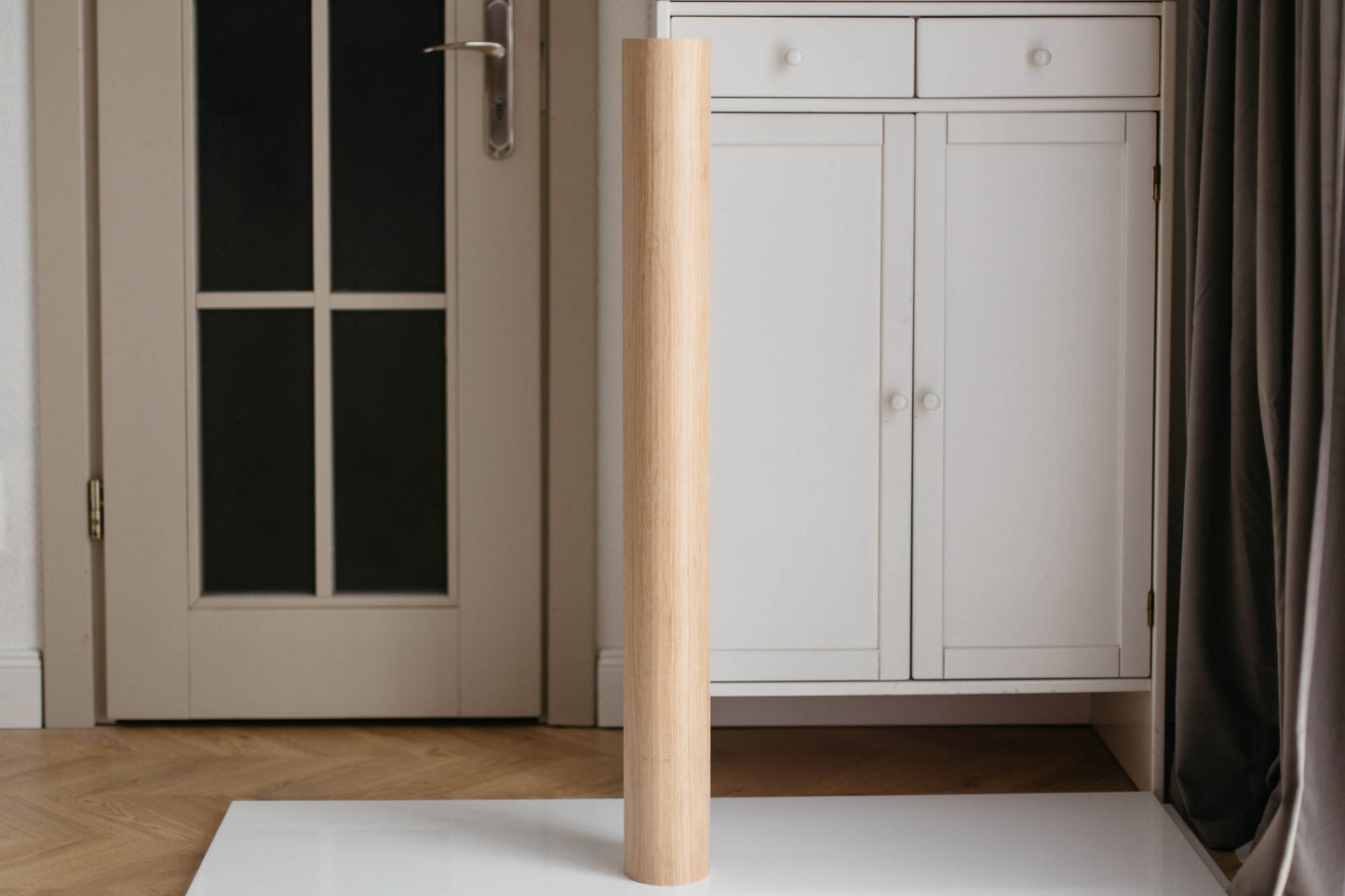 Wooden leg of a piece of furniture against a neutral background