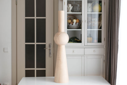 Decorative vase on a table with a glass cabinet in the background