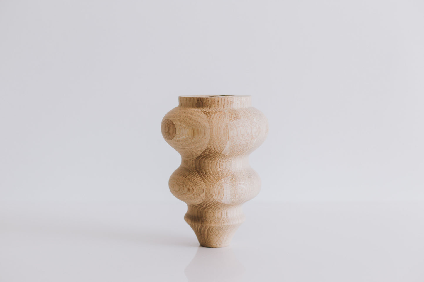 Wooden vase with a textured design on a white background