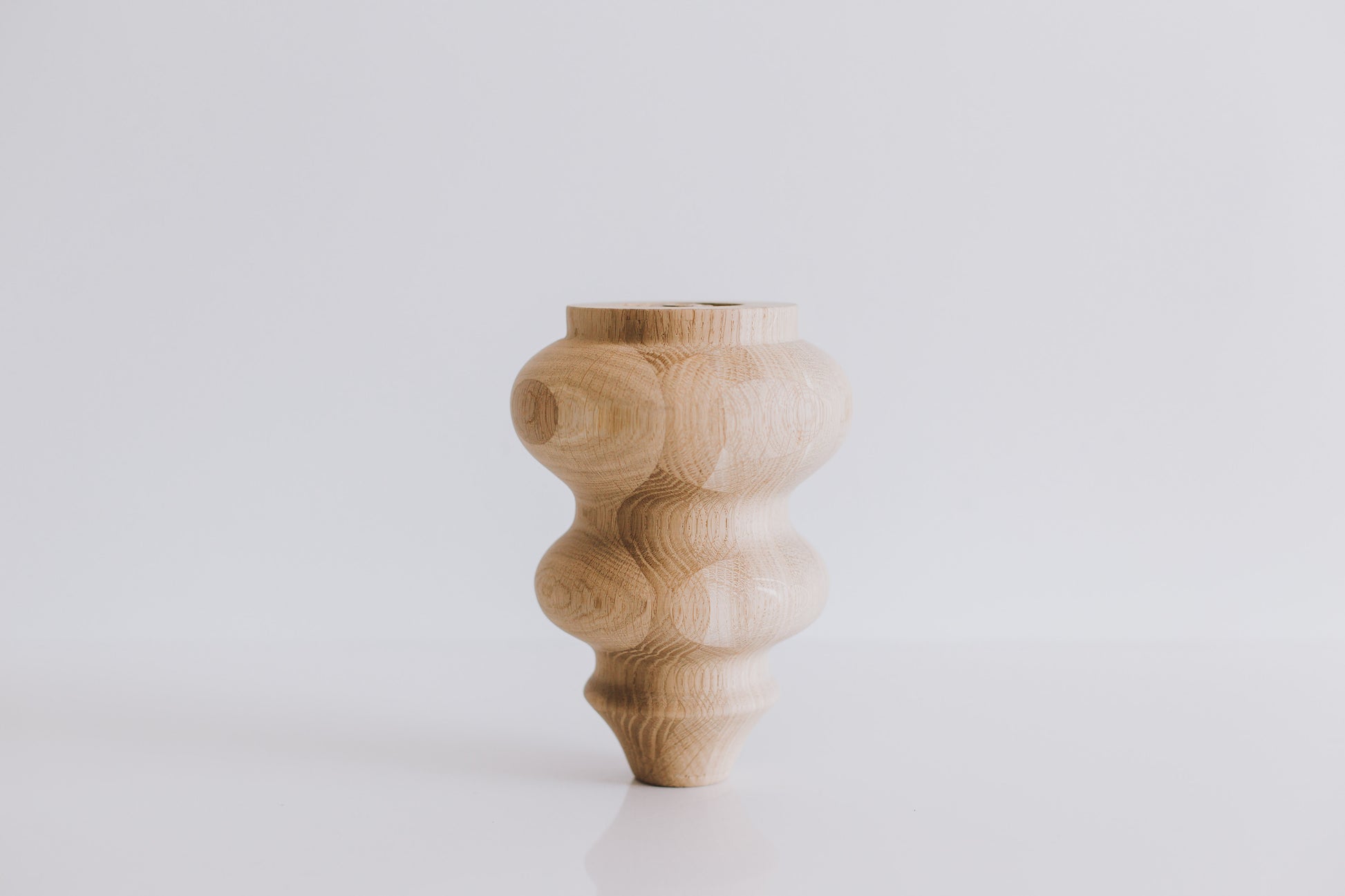 Wooden vase with a textured design on a white background