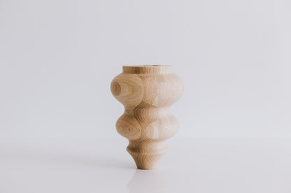 Wooden vase with a textured design on a white background