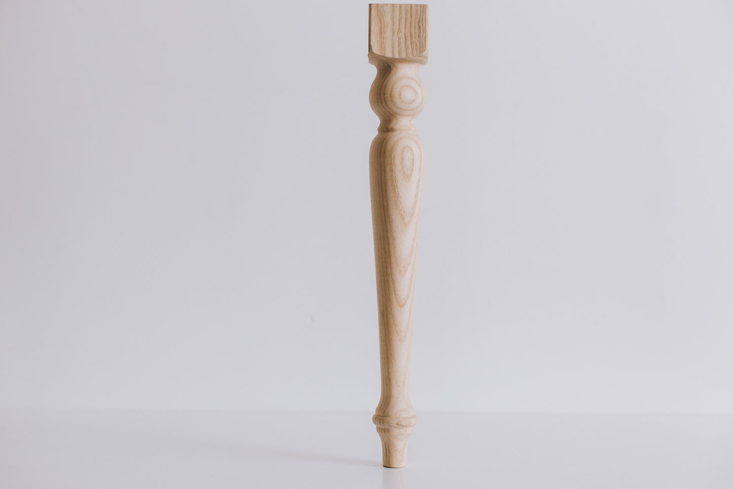 Wooden table leg on a light gray background