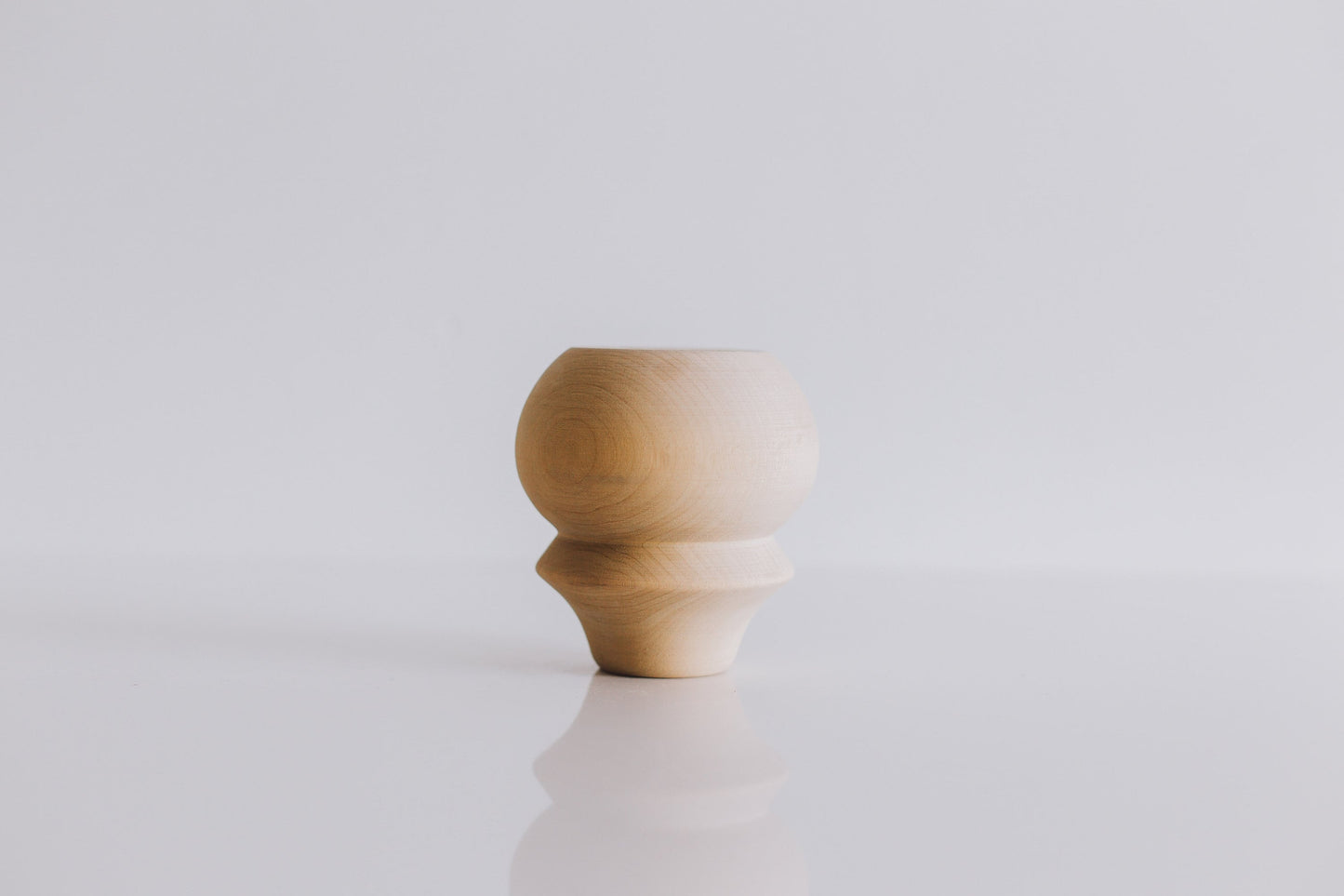 A single wooden furniture leg with a rounded shape on top, placed against a white background.